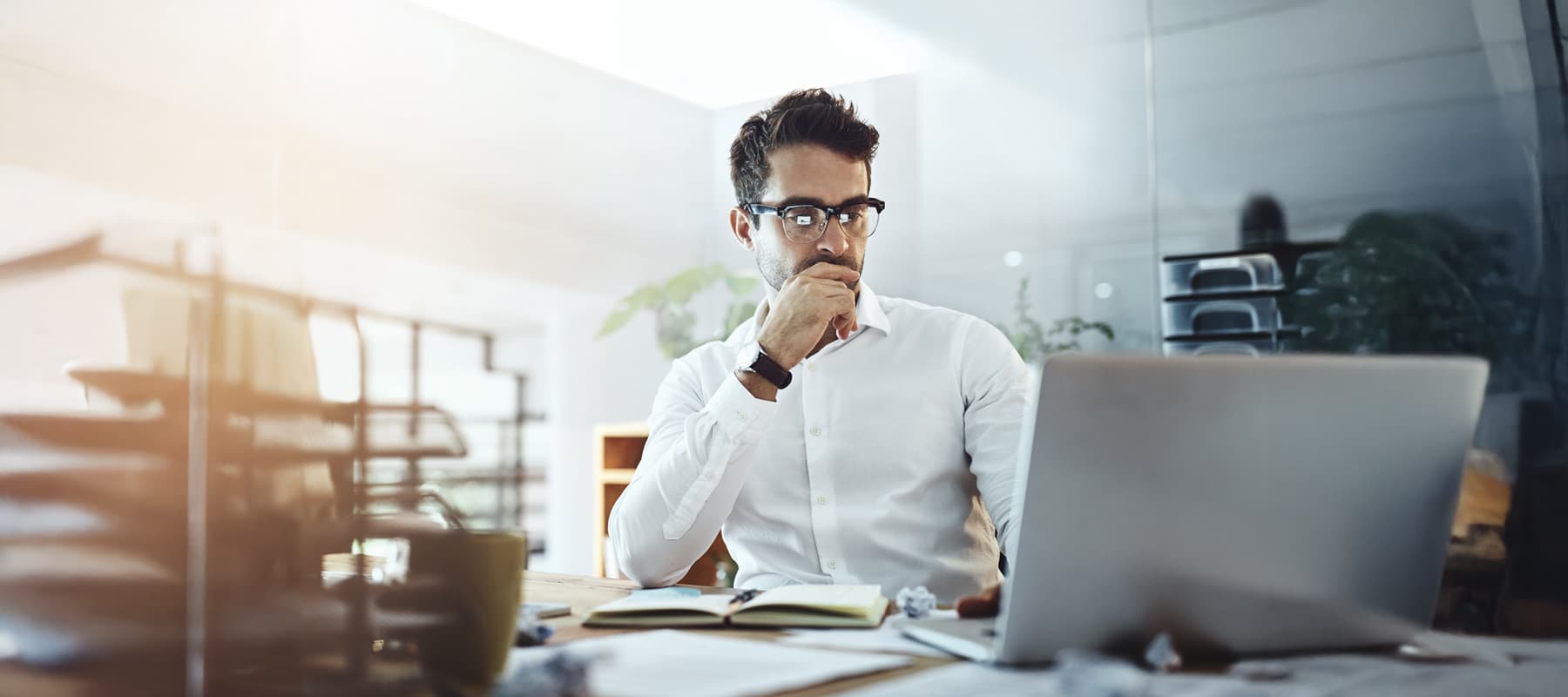 AI generated content image of a man at his desk concentrating on his laptop's work